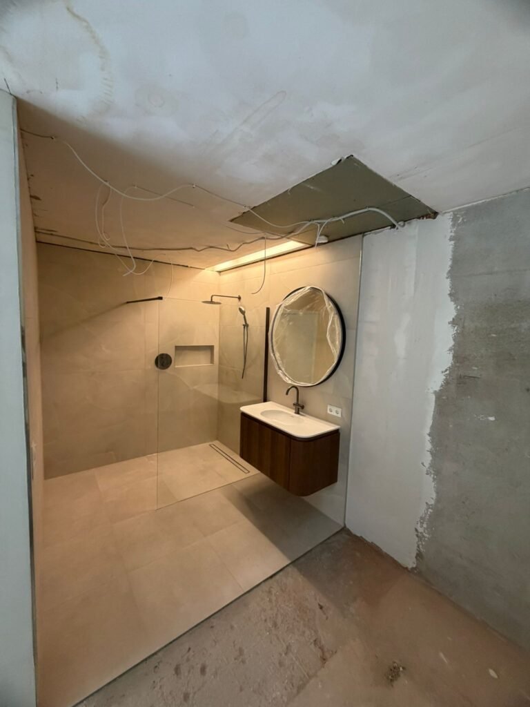 Gestript plafond en wand met losse bedrading tijdens sloopfase van een badkamerrenovatie — Niscon Group Noord-Brabant
