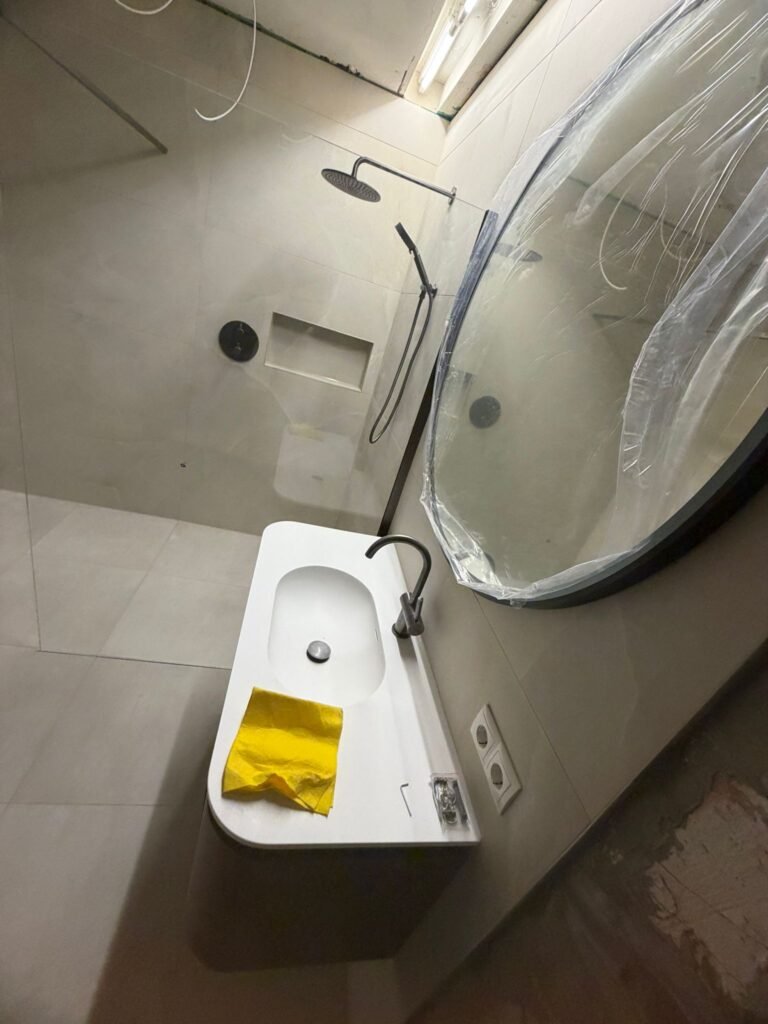 Mat zwarte regendouche met handdouche op betegelde wand tijdens badkamerrenovatie — Niscon Group Noord-Brabant
